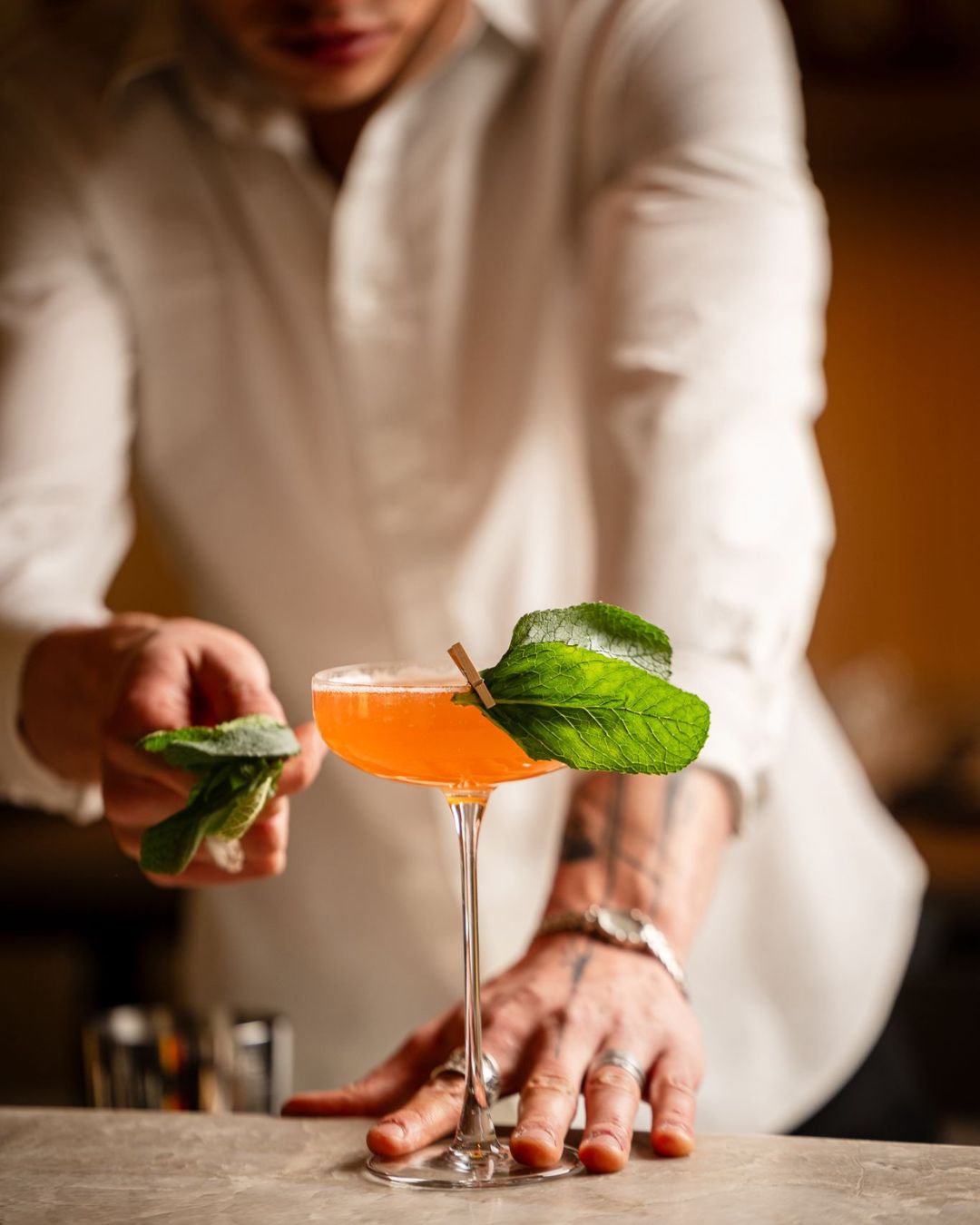Person bereitet einen Cocktail mit Minze zu